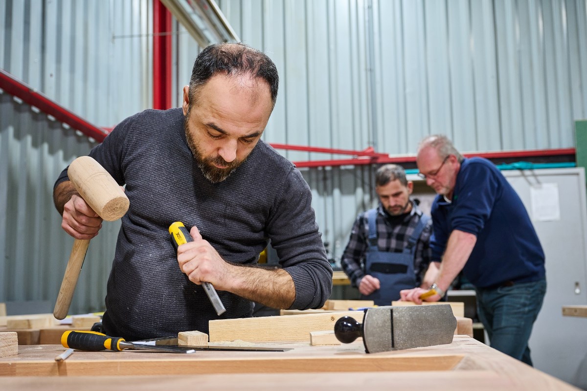 Statushouder aan het werk in houtwerkplaats